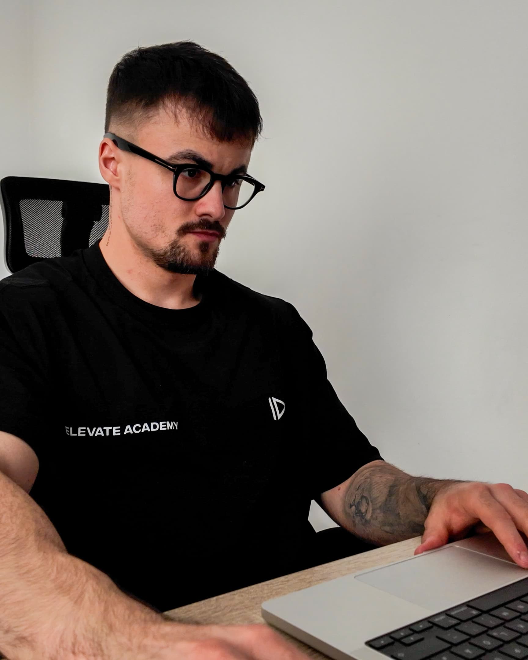 Maks working at his desk in an Elevate Academy shirt